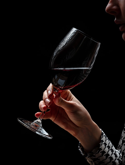 Una joven disfrutando de una copa de vino en un ambiente acogedor para celebrar la Navidad en el restaurante Dans le Noir ?