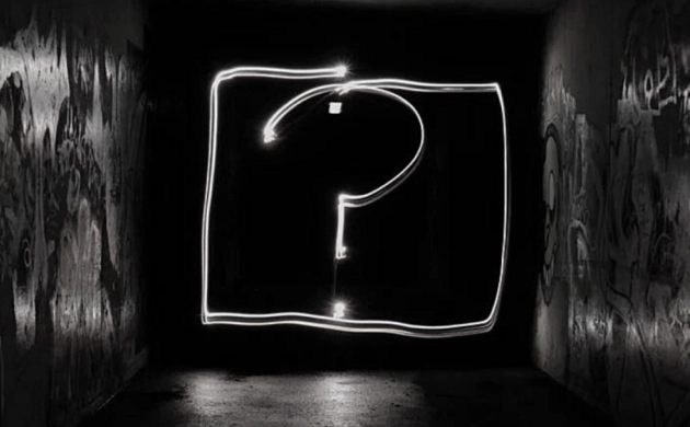 Un point d'interrogation lumineux dessiné dans l'obscurité d'un tunnel, symbolisant mystère et exploration sensorielle.