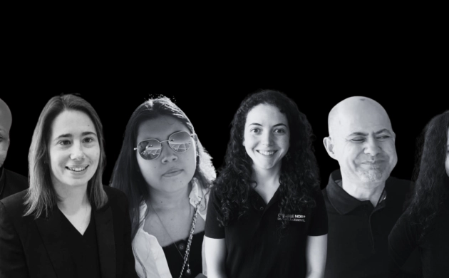 Portrait en noir et blanc de six personnes souriantes portant un polo avec l’inscription « Dans le Noir ? » sur fond noir.